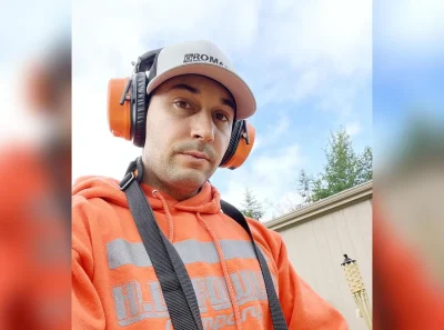 Isaac White, owner of Action Leak Detection, wearing headphones to listen for a hidden underground water leak with his detection equipment